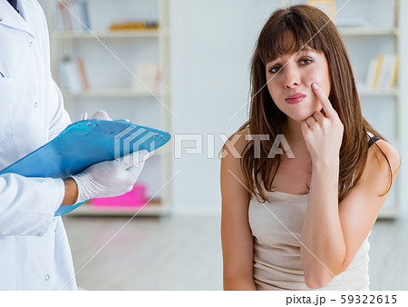 Doctor examining the skin of female patient Doctor examining the skin of female patient 59322615