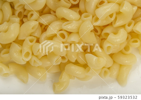 Boiled yellow pasta on a white plate. 59323532
