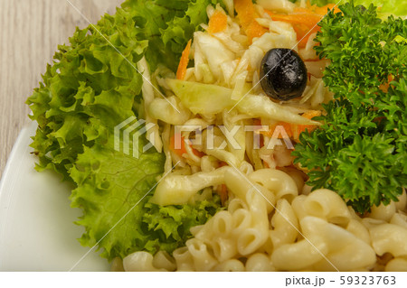 Pasta with a piece of grilled meat and salad. 59323763