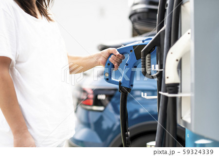 Woman charge Electric car on gas station. Blue car 59324339