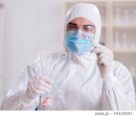 Expert criminologist working in the lab for evidence Expert criminologist working in the lab for evidence 59326091