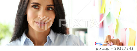 Beautiful female clerk drawing something on whiteboard during business conversation Beautiful female clerk drawing something on whiteboard during business conversation 59327543