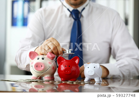 Funny businessman listen three piggybanks for cash 59327748