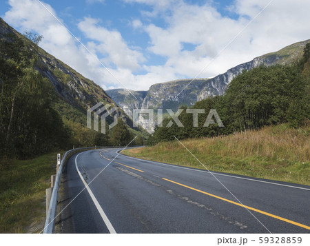 Winding road E136 with mountain massif 59328859