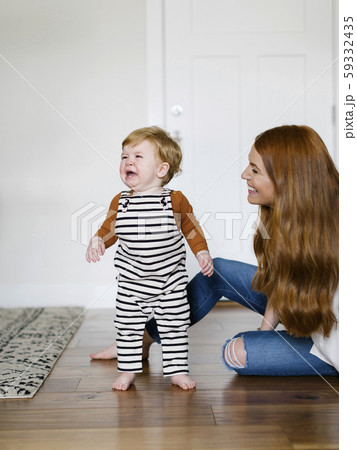 Mother smiling by her crying son Mother smiling by her crying son 59332435