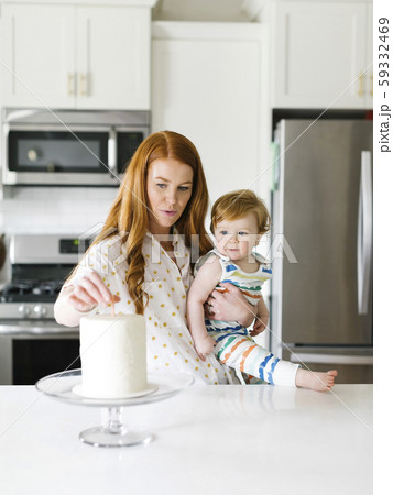 Mother and baby boy by birthday cake 59332469
