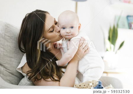 Mother kissing her baby boy's cheek Mother kissing her baby boy's cheek 59332530