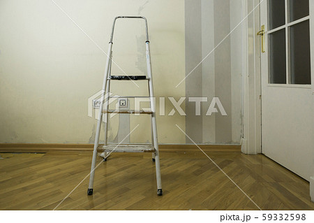Step ladder by wall of torn wallpaper 59332598