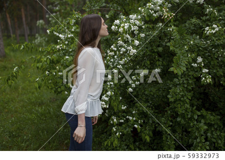 Young woman smelling flowers 59332973