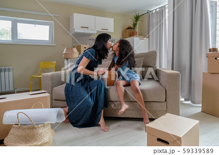 Mom with daughter pack things for relocation, mixed race family, African American daughter and Asian Mom with daughter pack things for relocation, mixed race family, African American daughter and Asian 59339589