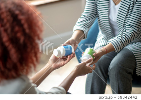Psychologist wearing grey trousers handing antidepressants to patient Psychologist wearing grey trousers handing antidepressants to patient 59342442