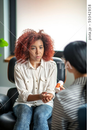 Young woman listening to psychoanalyst recommending antidepressants 59342858