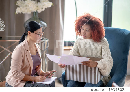 Mature psychoanalyst wearing glasses speaking with client 59343024