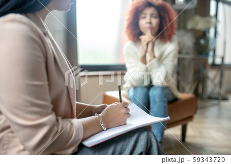 Close up of psychoanalyst wearing bracelet making notes 59343720