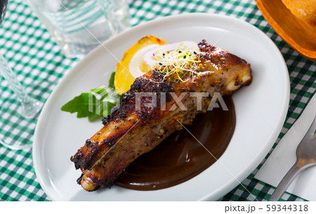 Broiled pork ribs in chocolate sauce with baked potato Broiled pork ribs in chocolate sauce with baked potato 59344318