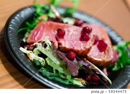 Slices of raw tuna with herbs and pomegranate 59344475