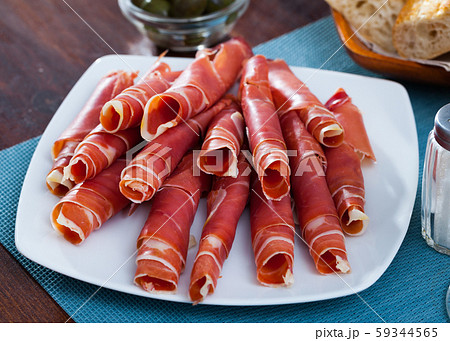 Traditional Spanish meal - rolls of iberian jamon served at plate 59344565