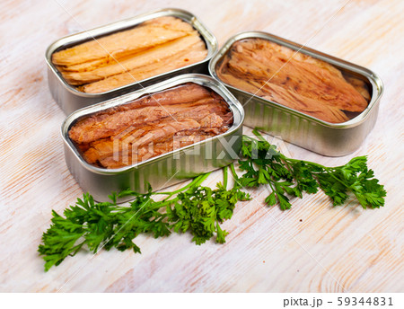 Natural frigate mackerel fillets and parsley can on wooden table 59344831
