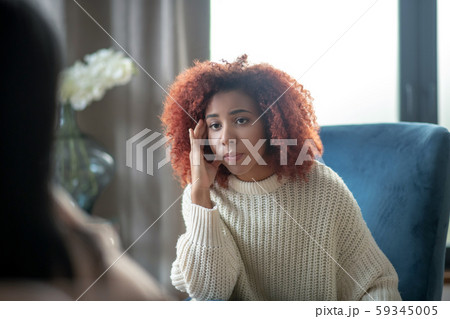 Young woman feeling concerned while having psychoanalysis 59345005