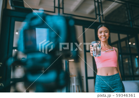 Young fitness trainer drinking water before exercising 59346361