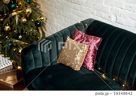 Christmas gift boxes on a wooden floor near a Christmas tree and a green sofa. Christmas gift boxes on a wooden floor near a Christmas tree and a green sofa. 59348642