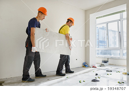 Installing a large ceramic tile. 59348707