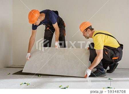 Installing a large ceramic tile. Installing a large ceramic tile. 59348708