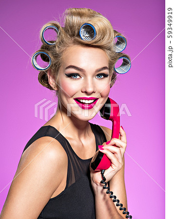 Girl with blue curlers talking by an old red 59349919