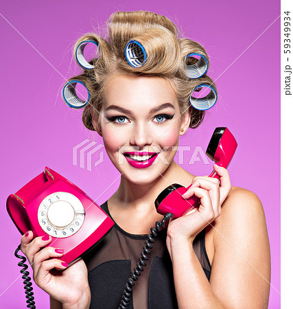 Smiling girl with blue curlers talking by an old 59349934