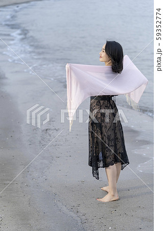 海岸の波打ち際を裸足で優雅に散歩する若い女性のライフスタイル一人旅 海岸の波打ち際を裸足で優雅に散歩する若い女性のライフスタイル一人旅 59352774