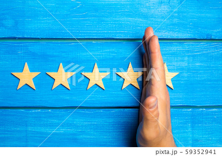 The hand divides the fifth star from the four others. Rating 5 stars, 4 stars. Overview of restaurant, hotel, cafe. The deterioration of the rating, the loss of the fifth star. Quality . Wooden stars 59352941