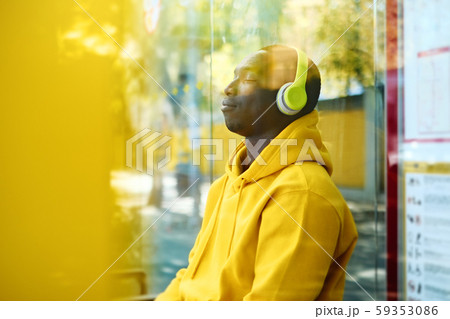 African Young Man Listening To Music At Bus Stop 59353086