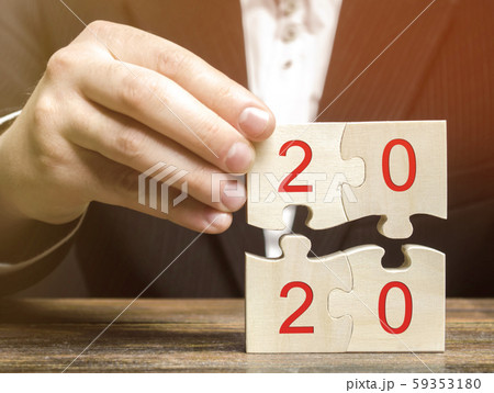 Businessman collects wooden puzzles with the inscription 2020. New Year concept. Plan, planning. Business goals and strategy for the future. Businessman collects wooden puzzles with the inscription 2020. New Year concept. Plan, planning. Business goals and strategy for the future. 59353180