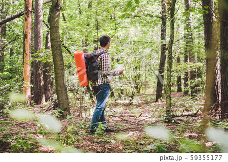 Man with Backpack and map searching directions in wilderness area. Tourist with backpack using map Man with Backpack and map searching directions in wilderness area. Tourist with backpack using map 59355177