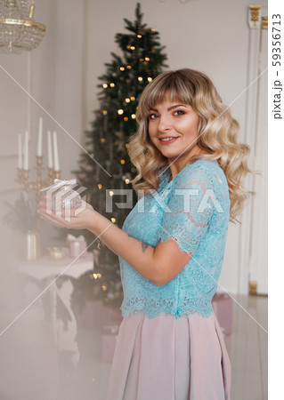 Young woman decorates Christmas tree with Christmas toys Young woman decorates Christmas tree with Christmas toys 59356713