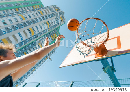 Outdoor portrait street basketball player playing with the ball on sunny day 59360958