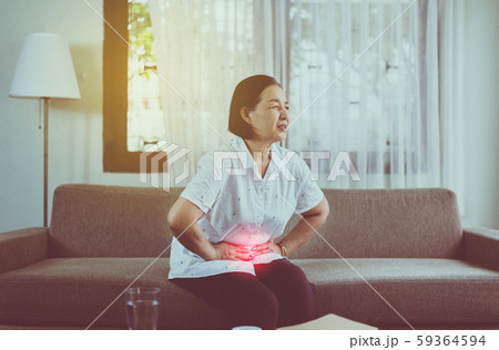 Elderly asian woman having stomachache while sitting on sofa at home,Senior female suffering from abdominal pain Elderly asian woman having stomachache while sitting on sofa at home,Senior female suffering from abdominal pain 59364594