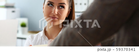 Male worker show pack of papers to busy beautiful female 59370341