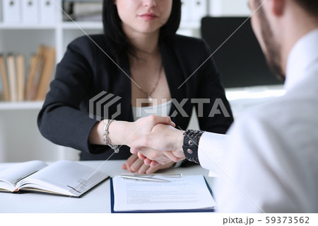 Businessman and woman shake hands as hello in office 59373562