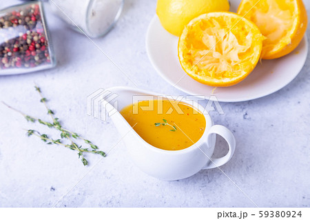 Orange sauce for duck (poultry) in a white gravy boat. Close-up, selective focus. 59380924