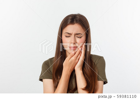 Teen woman pressing her bruised cheek with a painful expression as if she is having a terrible tooth 59381110