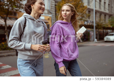 Positive delighted young females having pleasant conversation Positive delighted young females having pleasant conversation 59384089