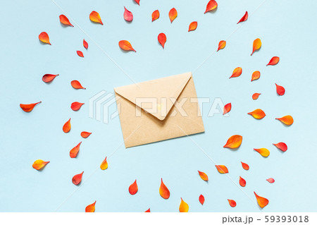 Paper envelope with small orange and red autumn leaves on a blue background. Paper envelope with small orange and red autumn leaves on a blue background. 59393018
