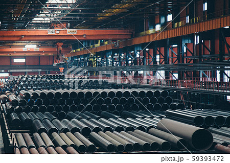 heavy industry concept, construction machinery - long metal pipes inside a large room. Building 59393472
