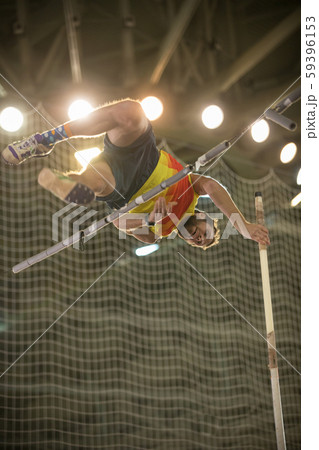Pole vaulting - man is jumping over the bar and is going to let go of the pole 59396153