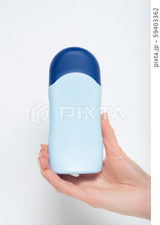 Blue bottle for cosmetic product in a female hand. 59403362