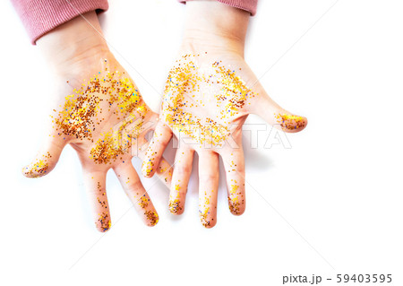 Little child with gold glitter on hands against white background, top view 59403595