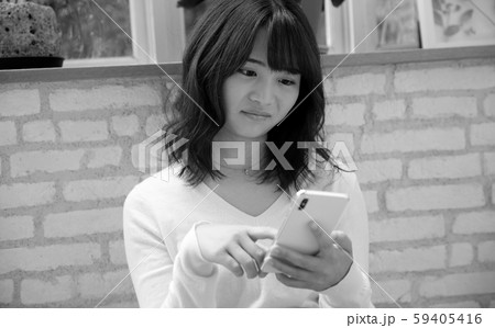 自宅にてスマホを操作する女性イメージ 自宅にてスマホを操作する女性イメージ 59405416