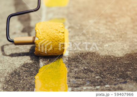 Male students use small paint rollers to paint yellow lines on the cement floor for Sepak Takraw training 59407966