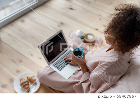 Young woman working on notebook and drinking coffee 59407967